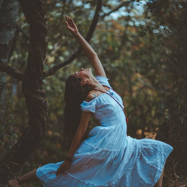Woman in a tree pose, balancing gracefully in nature.